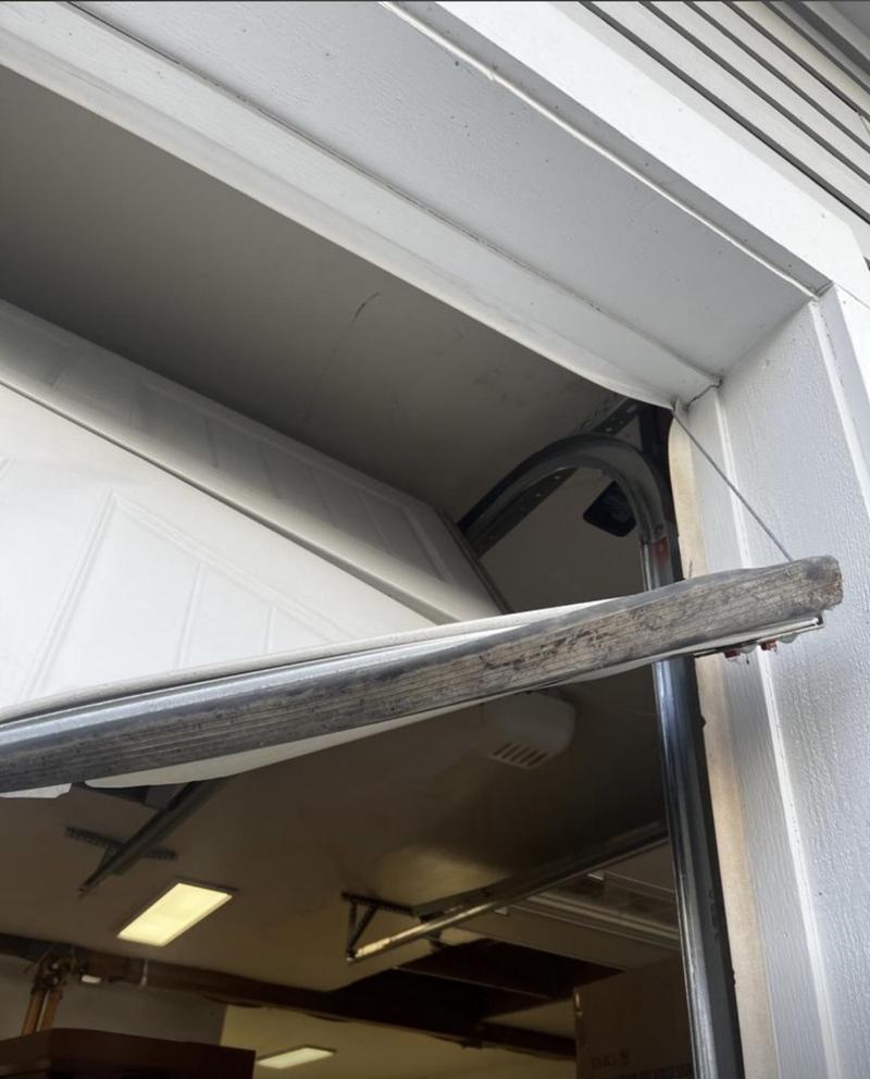 Garage door hanging crooked in the opening after a lift cable came off its drum
